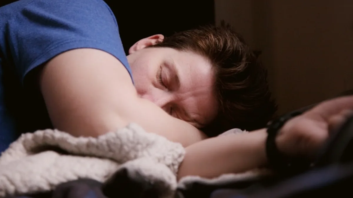 person checking clock in bed while feeling restless