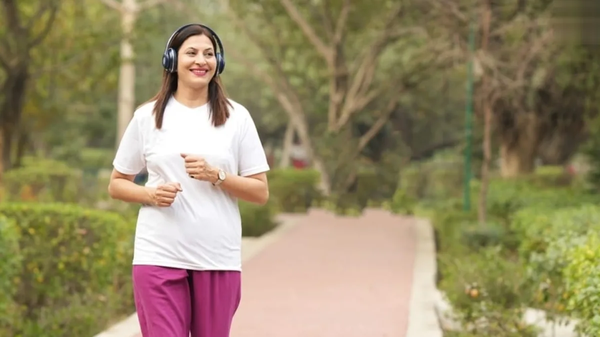 A person walking in a park with a brain-shaped balloon in the background