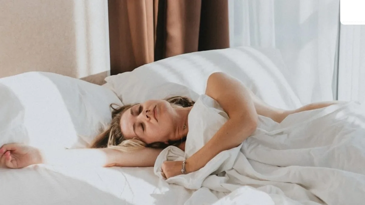 A person sleeping with a clock in the background