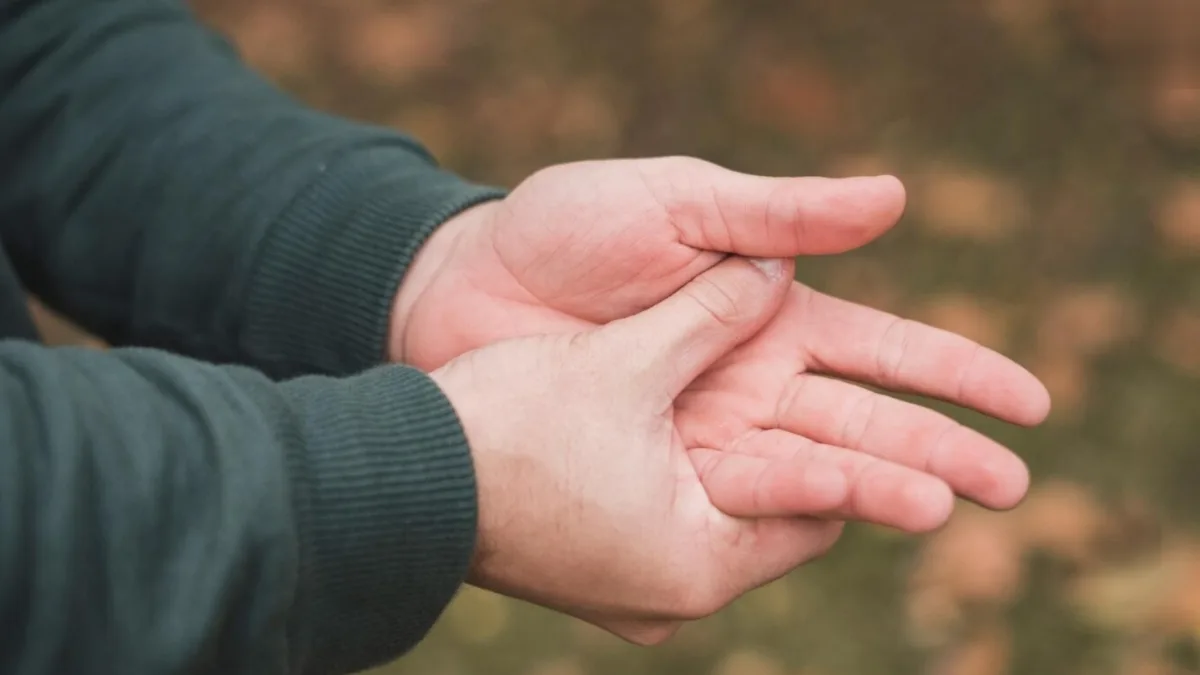 A person holding their arm in discomfort due to numbness