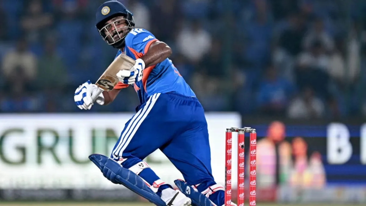 Sanju Samson focused on the field with a laptop displaying a Wi‑Fi symbol