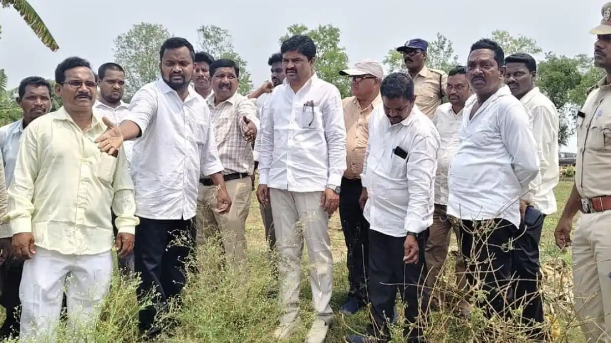 A photo of a Dalit farmer standing in front of his land, with a sign that reads 'Dalit Land Rights'