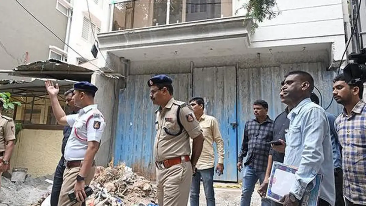 Police personnel at the under-construction building on Jeremiah Road in east Bengaluru