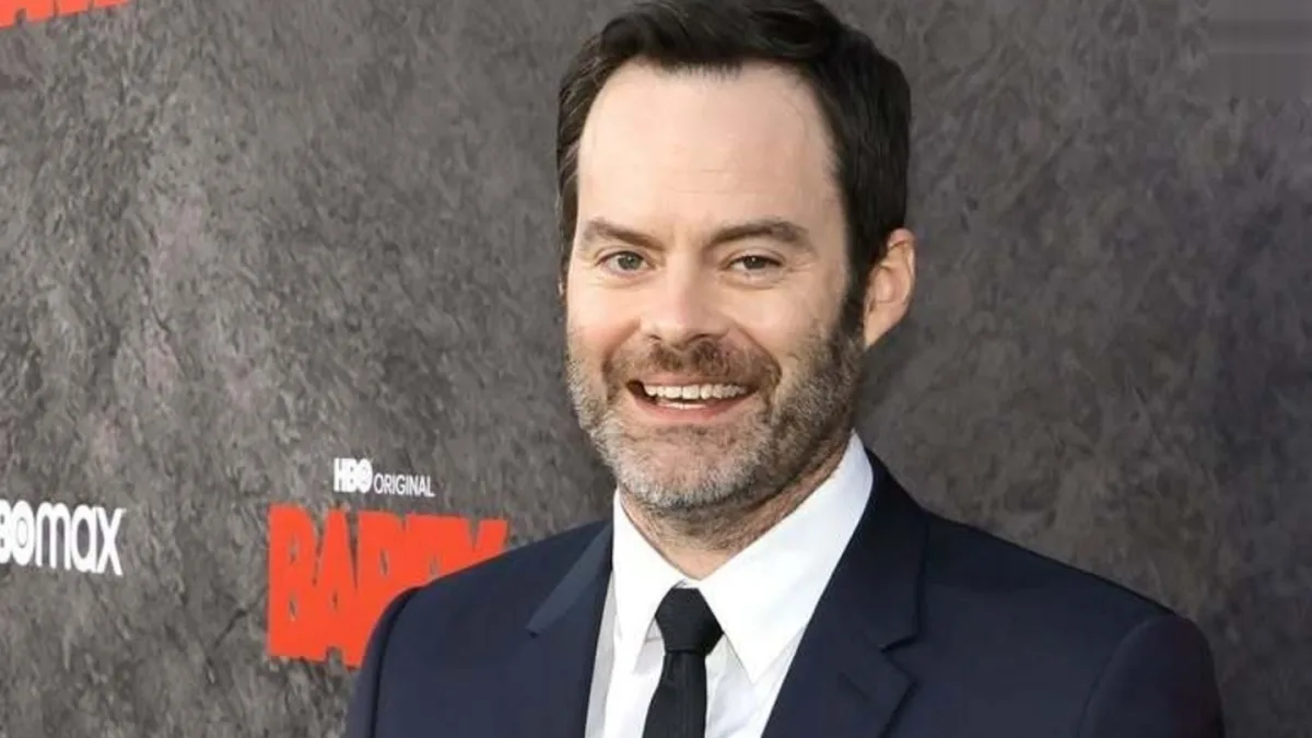 Bill Hader smiling and holding a microphone
