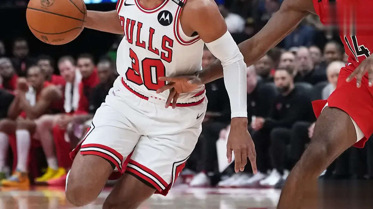 A basketball player in action, with the Bulls and Bucks logos in the background