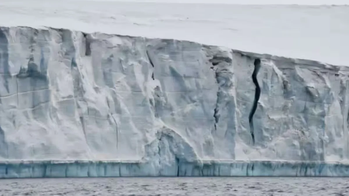A photo of a glacier with a tall ice cliff in the background
